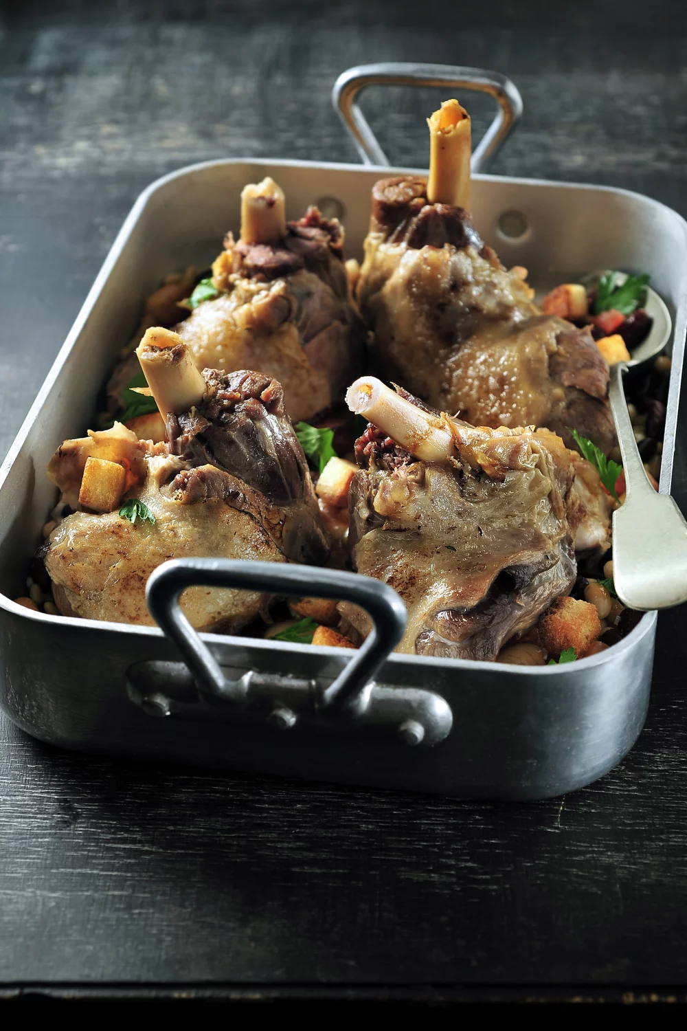 Gekonfijte lamsschenkel met bonenschotel en croutons