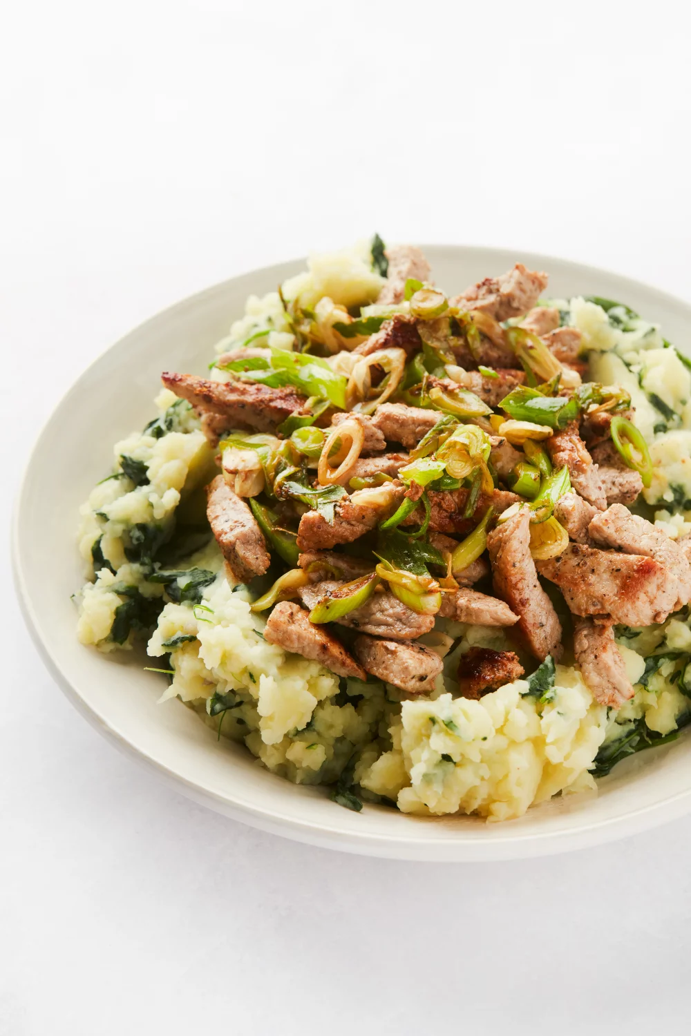 Kalfslapjes met spinaziepuree en gesmoorde lente-ui