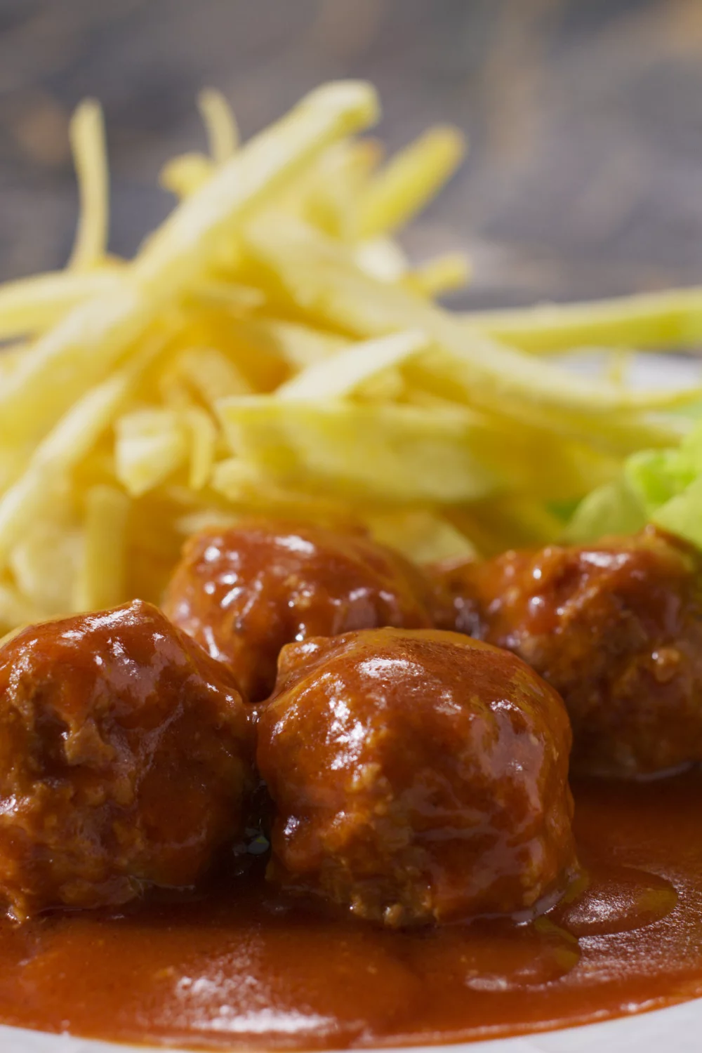 Balletjes in tomatensaus met kropsla en frietjes