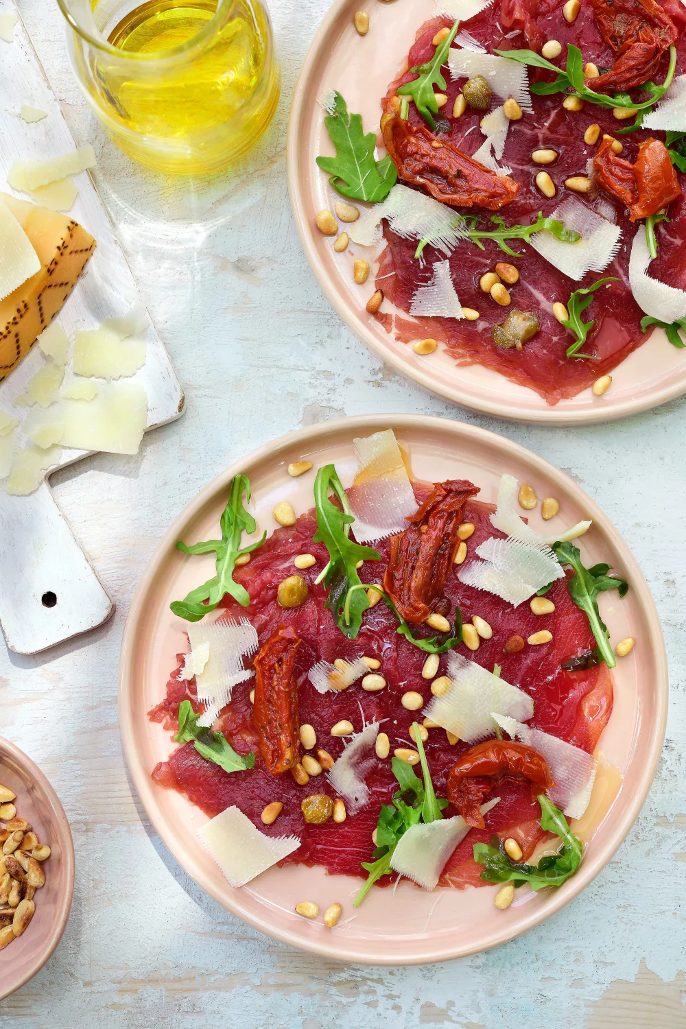Carpaccio met zongedroogde tomaatjes, rucola en geroosterde pijnboompitjes