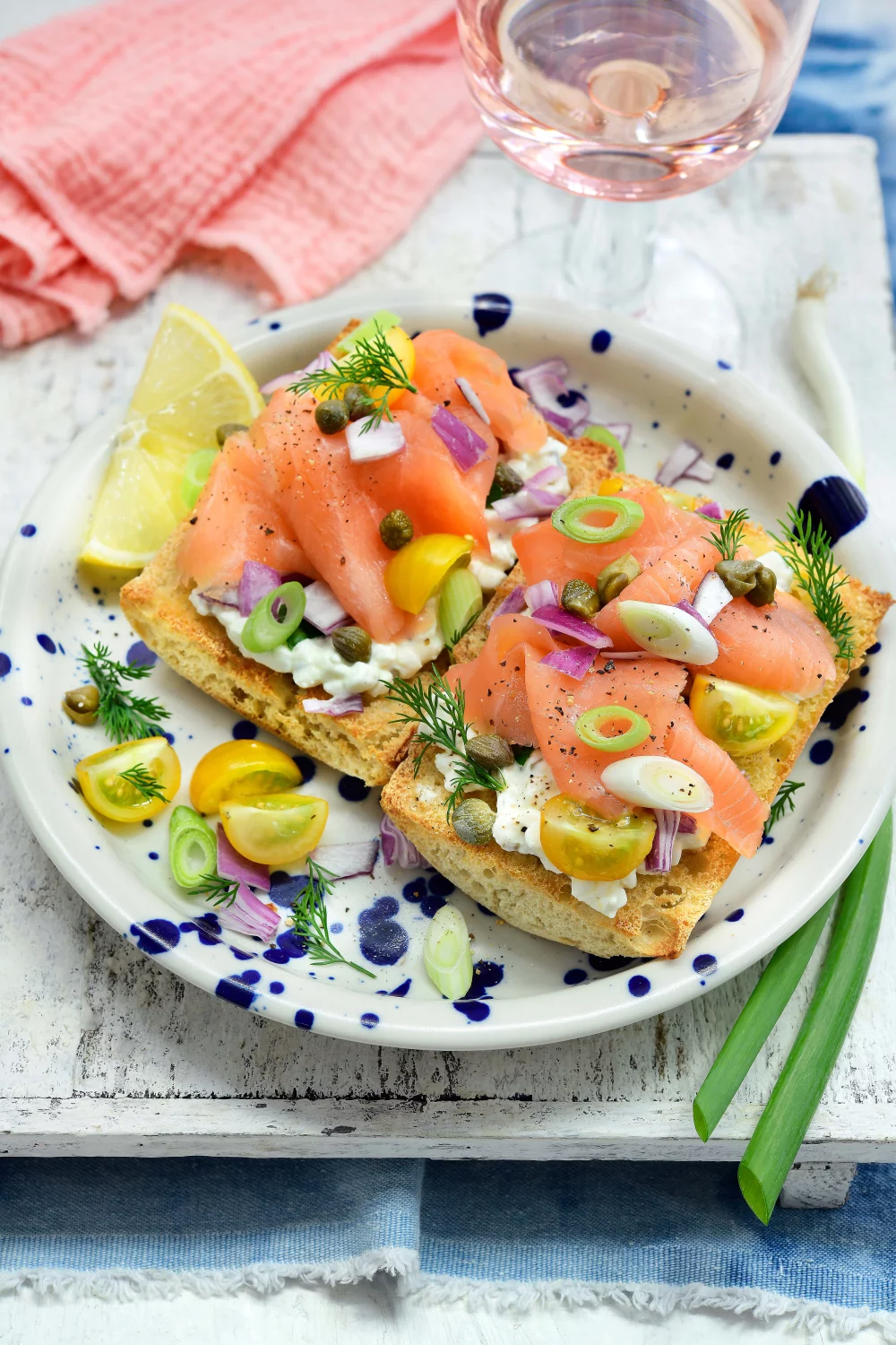 Toast met cottage cheese, gerookte zalm, kappertjes, rode ui en gele kerstomaatjes
