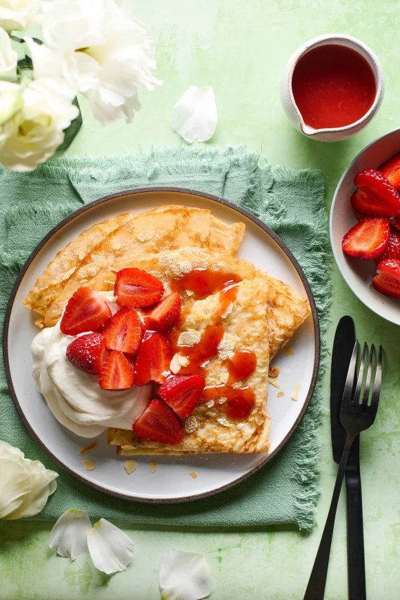 Lekker lichte pannenkoeken met opgeklopte room en verse aardbeien