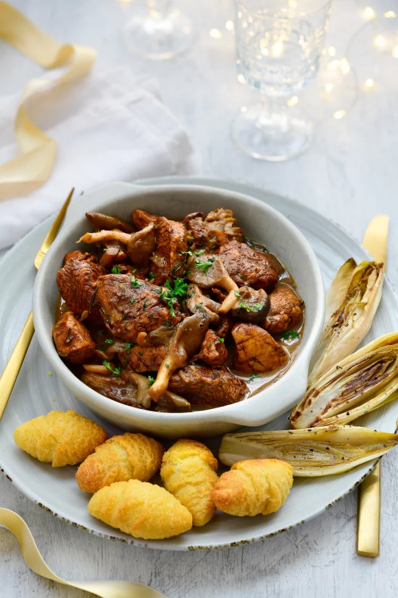 Stoofpotje van kalkoen met bospaddenstoelen, gestoofd witloof en dennenappelkroketjes