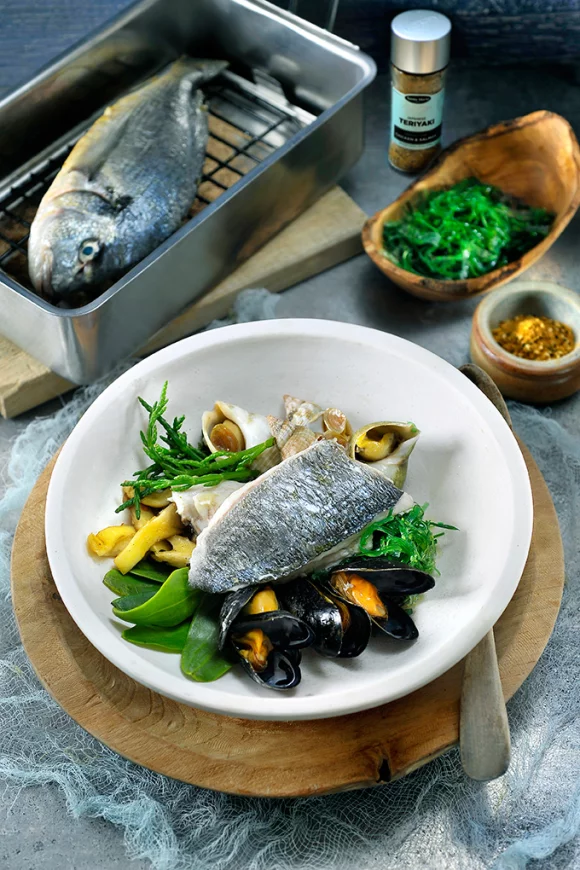 Warm gerookte zeebaars met rood zeewier, wakame en een kruidenolie