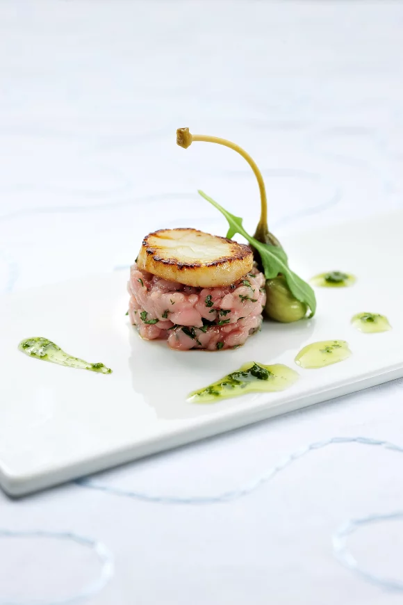 Kalfstartaar, sint-jakobsschelpen, avocadocrème, kapperappel en basilicumolie