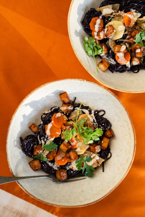 Zwarte rijstnoedels met ovengroenten, tofu en whipped tahindressing