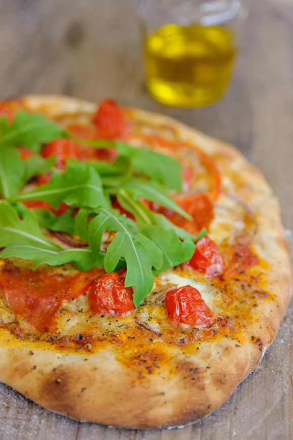 Pizza met salami, tomaat en rucola