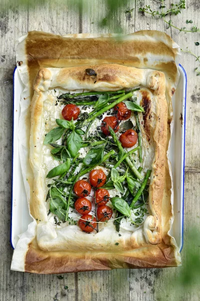 Bladerdeegtaart met geitenkaas, kerstomaten en groene asperges