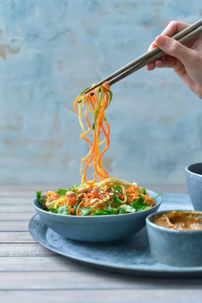 Oosterse courgetti met bruine rijstnoedels en pinda-gembersaus
